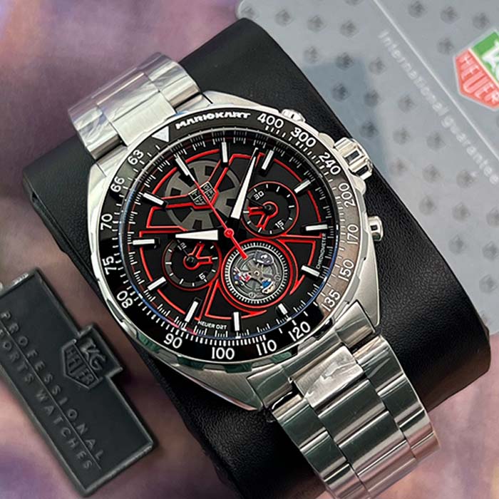 Reloj TAG Heuer Mario Kart Racing con correa de acero, detalles rojos, cronógrafo deportivo y tourbillon visible en la esfera.