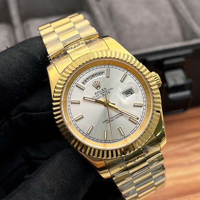 Reloj estilo Rolex Day-Date completamente dorado con esfera plateada y bisel estriado, ideal para hombres elegantes en Colombia.