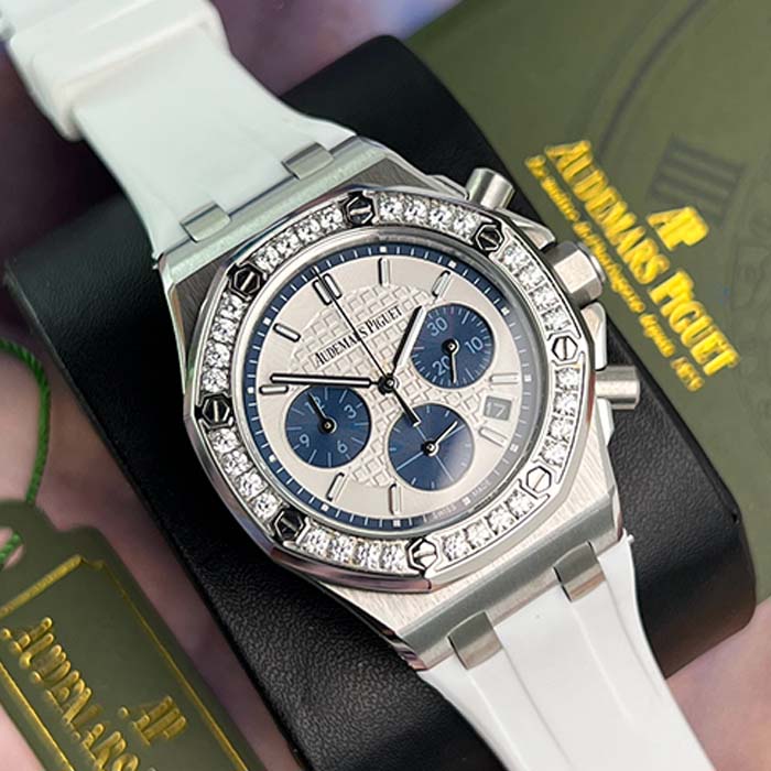 Reloj Audemars Piguet Royal Oak Lady con esfera blanca y azul, correa blanca y bisel con brillantes.