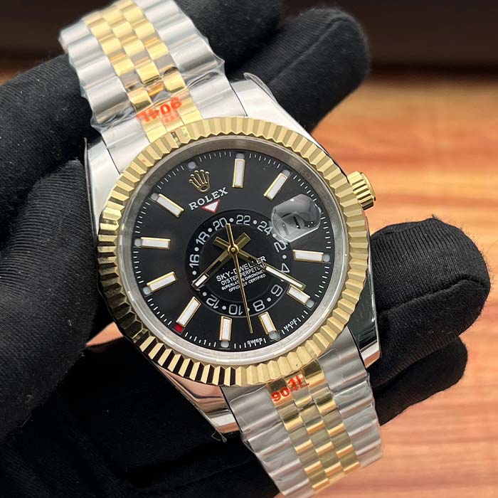 Reloj estilo Rolex Sky-Dweller con esfera negra, correa bicolor dorada y bisel estriado, ideal para hombres con estilo ejecutivo en Colombia.