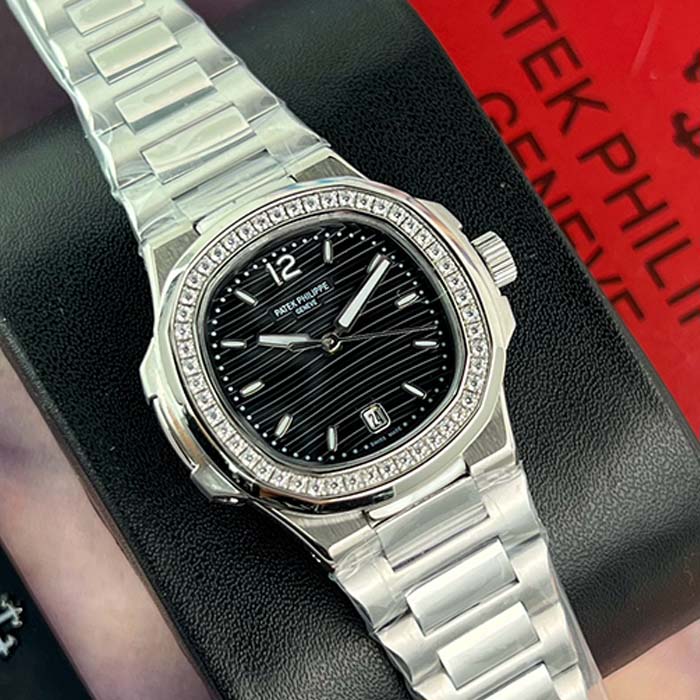 Reloj Patek Philippe Nautilus para mujer con esfera negra, bisel de diamantes y pulso metálico, ideal para un look sofisticado en Colombia.