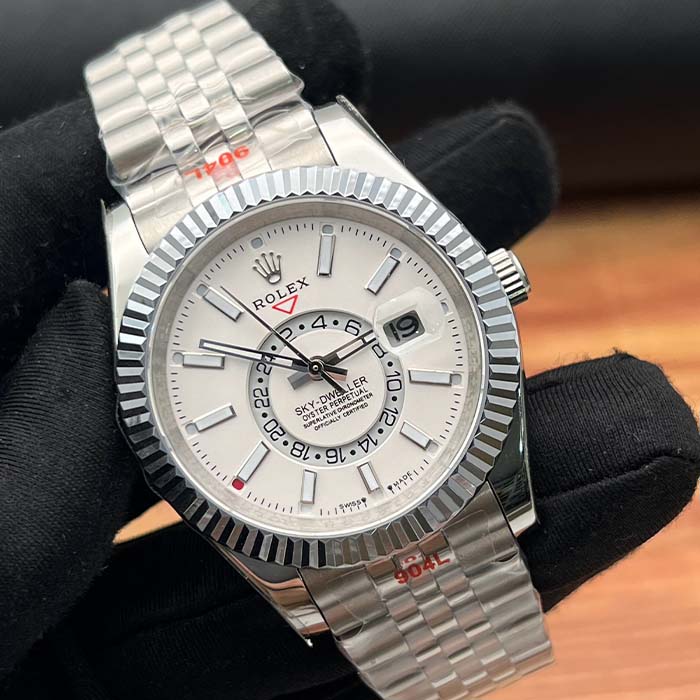 Reloj estilo Rolex Sky-Dweller en tono plateado con esfera blanca y bisel estriado, ideal para hombres elegantes y modernos en Colombia.