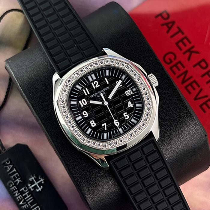 Reloj Patek Philippe Aquanaut para mujer con esfera negra, bisel con diamantes y correa deportiva de caucho negro.