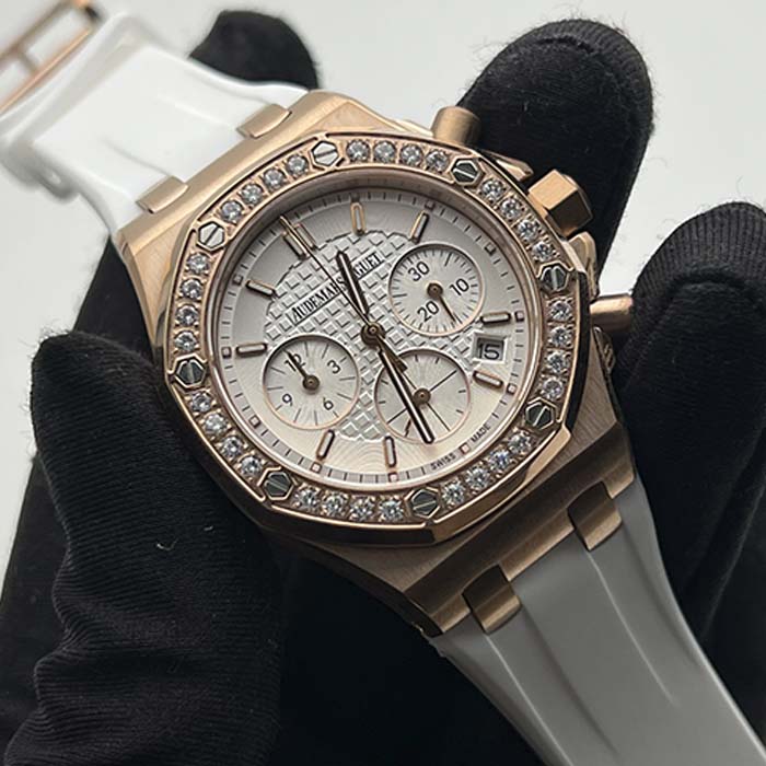Reloj Audemars Piguet Royal Oak para mujer en tono rosado con cronógrafo, correa blanca y bisel con brillantes.
