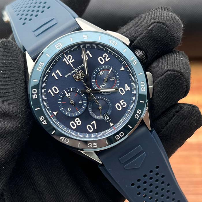 Reloj TAG Heuer Porsche color azul con cronógrafo funcional, correa deportiva de caucho y diseño inspirado en autos de lujo.