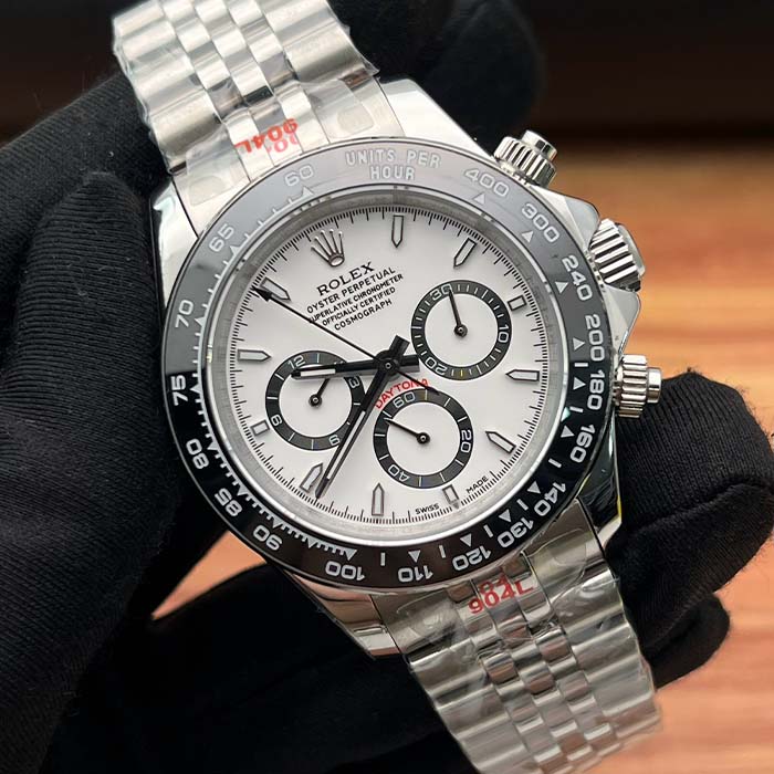Reloj tipo Rolex Daytona con esfera blanca y cronógrafos negros, bisel taquimétrico y correa de acero, ideal para hombres con estilo deportivo y elegante.