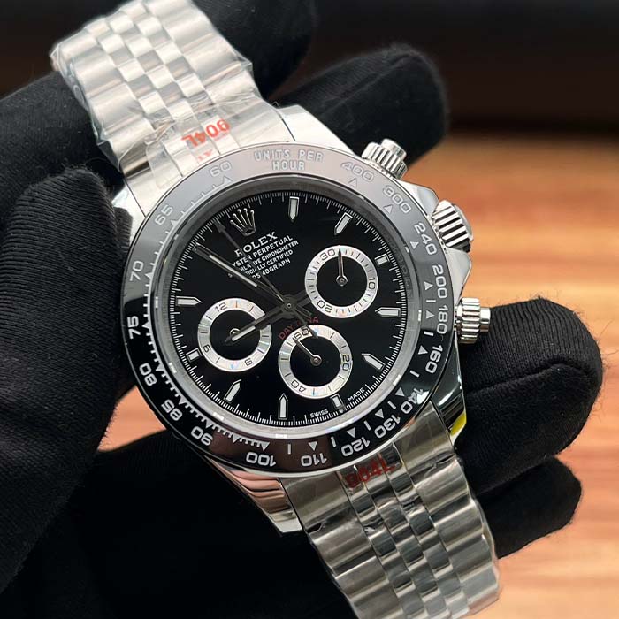 Reloj tipo Rolex Daytona en acero con esfera negra, cronógrafos plateados y bisel cerámico negro, ideal para hombres modernos en Colombia.