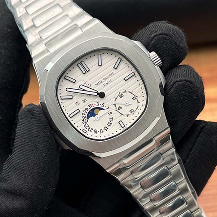 Reloj Patek Philippe Nautilus con carátula blanca, detalles de fase lunar y diseño sofisticado en acero para hombre.