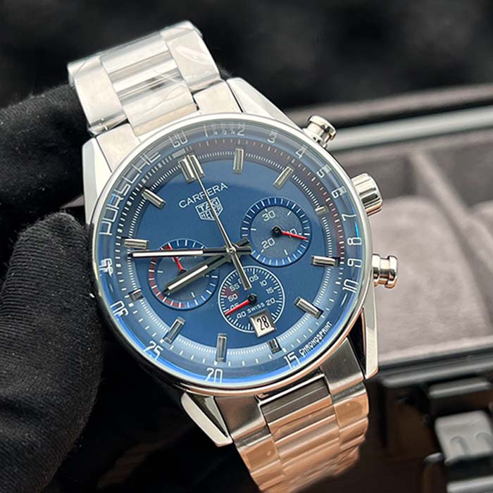 Reloj TAG Heuer Carrera Porsche con cronógrafo, esfera azul y brazalete de acero, estilo deportivo y elegante.
