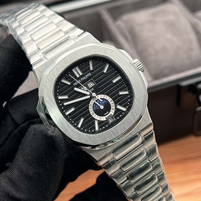 Reloj Patek Philippe Nautilus con carátula negra, fase lunar, calendario completo y correa de acero ideal para uso elegante y casual.