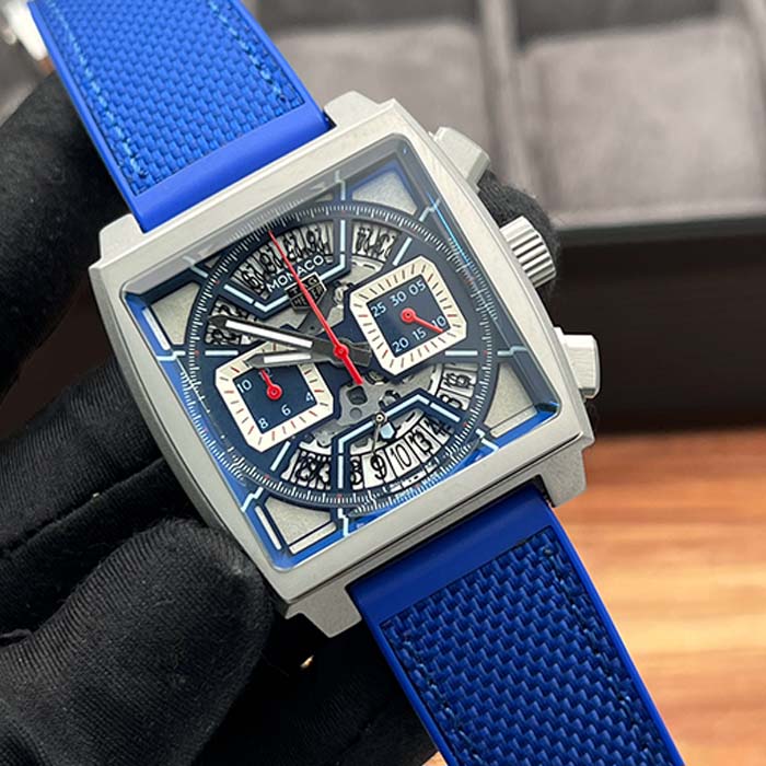 Reloj TAG Heuer Monaco skeleton con correa de caucho azul, caja cuadrada y diseño deportivo con cronógrafo visible, ideal para hombres con estilo.