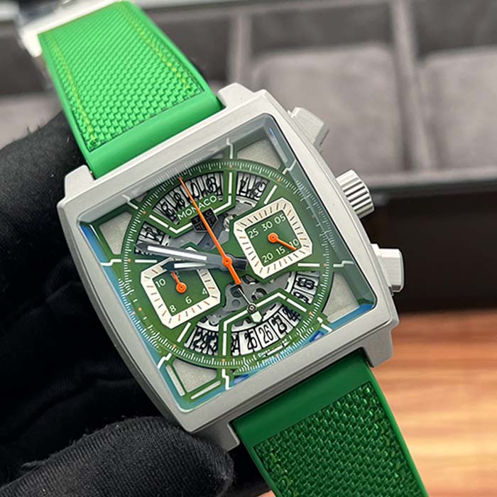 Reloj TAG Heuer Monaco con correa verde, caja cuadrada, cronógrafos funcionales y diseño moderno, ideal para uso casual y urbano.