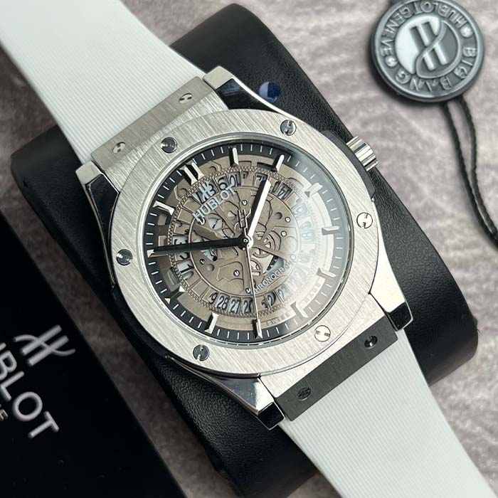 Reloj Hublot clásico con diseño skeleton, caja plateada y correa blanca, ideal para hombres con estilo sofisticado en Colombia.