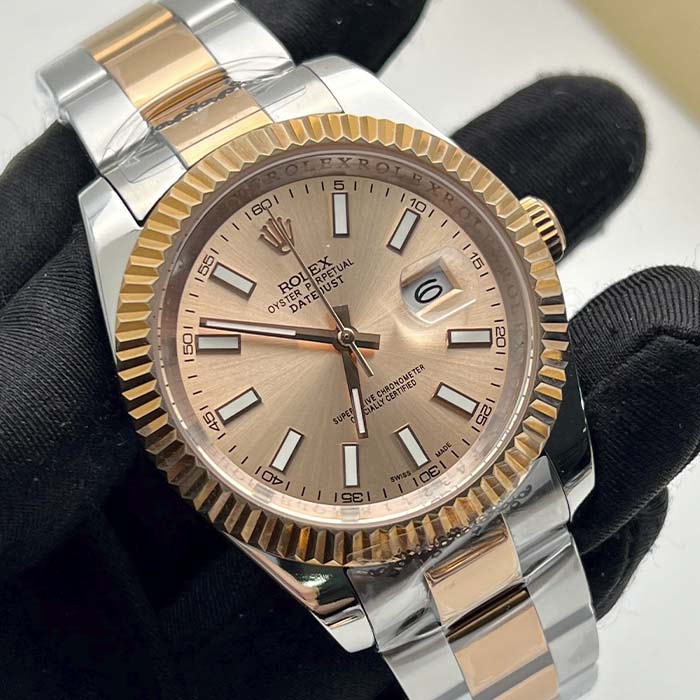 Reloj estilo Rolex Datejust con esfera rosado champaña y correa en acero con detalles dorados, ideal para hombres elegantes.