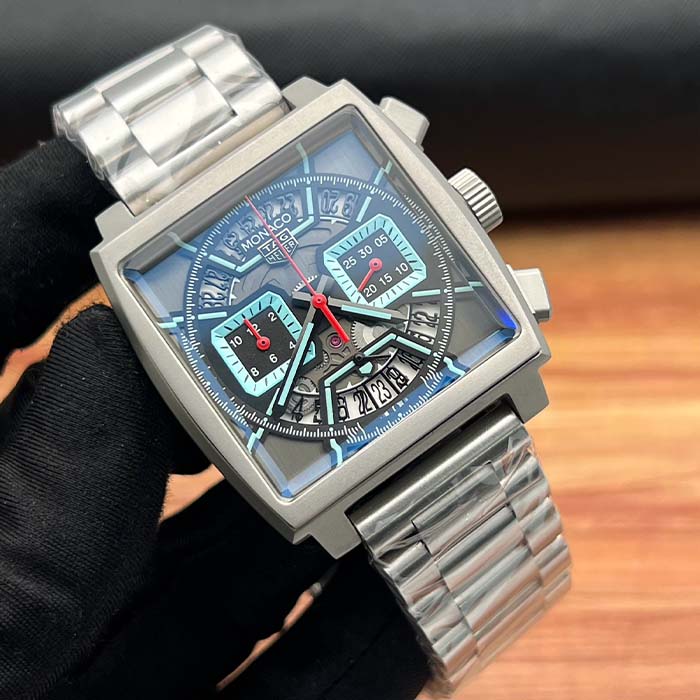 Reloj TAG Heuer Monaco con carátula transparente estilo skeleton en tonos azul hielo, con correa metálica y diseño cuadrado deportivo.