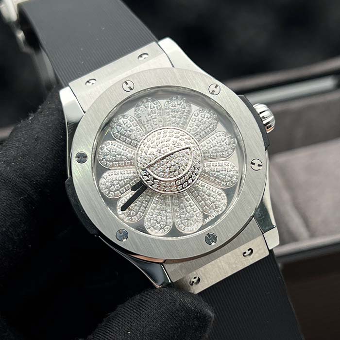 Reloj Hublot plateado con diseño de flor brillante en el dial y correa negra elegante, ideal para quienes buscan destacar con estilo en Colombia.