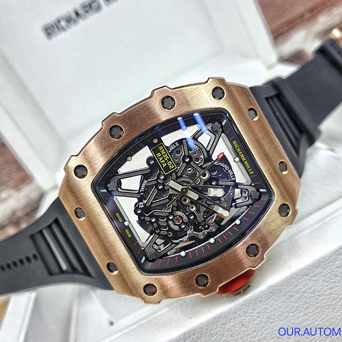 Reloj Richard Mille skeleton con caja en oro rosa, correa negra de caucho y diseño mecánico visible para estilo deportivo elegante.