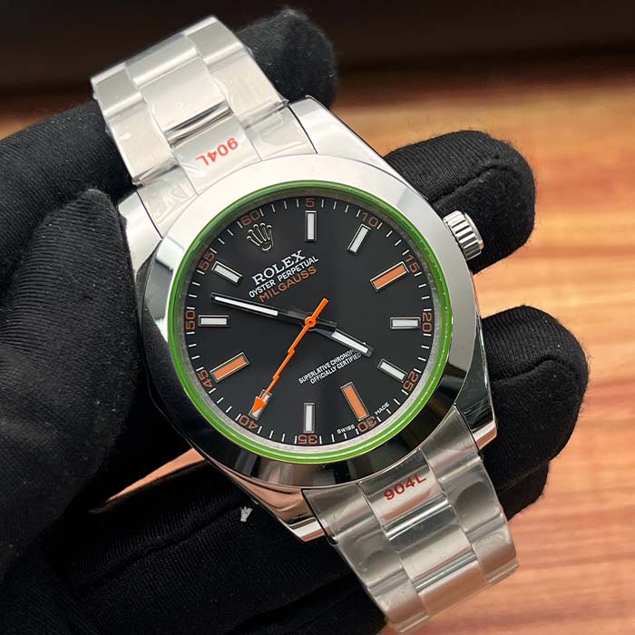 Reloj Rolex Milgauss con esfera negra, detalles en color naranja, bisel verde y correa de acero inoxidable, ideal para un estilo moderno y audaz.