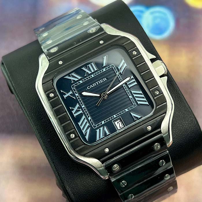 Reloj Cartier Santos en acabado negro con esfera azul oscuro, números romanos plateados y correa metálica, estilo elegante para hombre moderno.