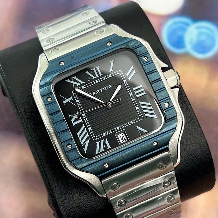 Reloj Cartier Santos con bisel azul metálico, carátula negra y correa de acero inoxidable, ideal para un estilo elegante y moderno.
