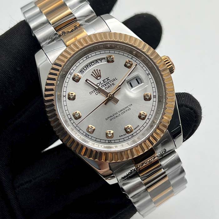 Reloj tipo Rolex Day-Date con esfera plateada, marcadores brillantes y correa dorado-acero para hombre elegante en Colombia.